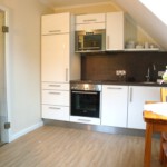 Küche mit Spülmaschine, Mikrowelle, Kühlschrank mit Gefrierfach und Backofen